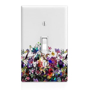 May include: A white light switch cover with a colorful floral design. The design features a variety of flowers and leaves in shades of pink, purple, blue, green, and yellow. The switch cover has the word "OFF" printed on the switch.