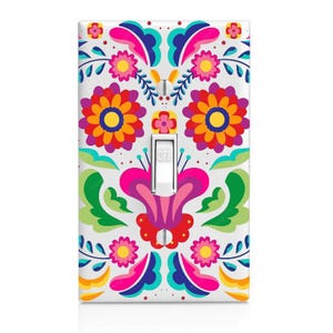 May include: A rectangular light switch plate featuring a vibrant, symmetrical floral pattern on a white background. The design includes orange, pink, yellow, green, and blue stylized flowers and leaves. A white toggle switch is centered with the text OFF.