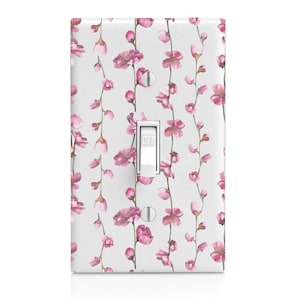 May include: White light switch cover with a pink floral pattern. The pattern features delicate pink flowers and green stems.