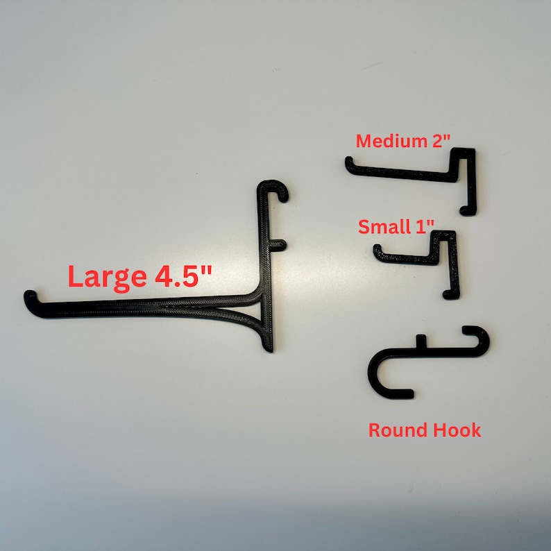 May include: Black 3D-printed display hooks in various sizes. The image shows a large hook at 4.5 inches, a medium hook at 2 inches, a small hook at 1 inch, and a round hook. The text labels each hook's size.
