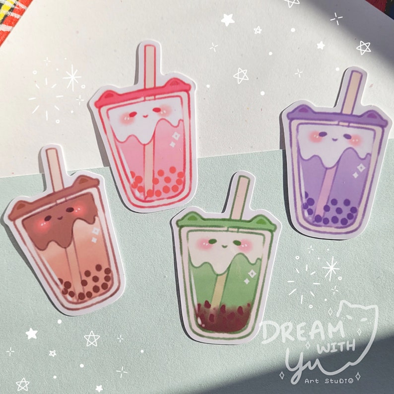 May include: Four illustrated stickers of boba tea with different coloured drinks and toppings. The stickers are on a light blue background with white stars and sparkles. The text "DREAM WITH yu" is at the bottom of the image.