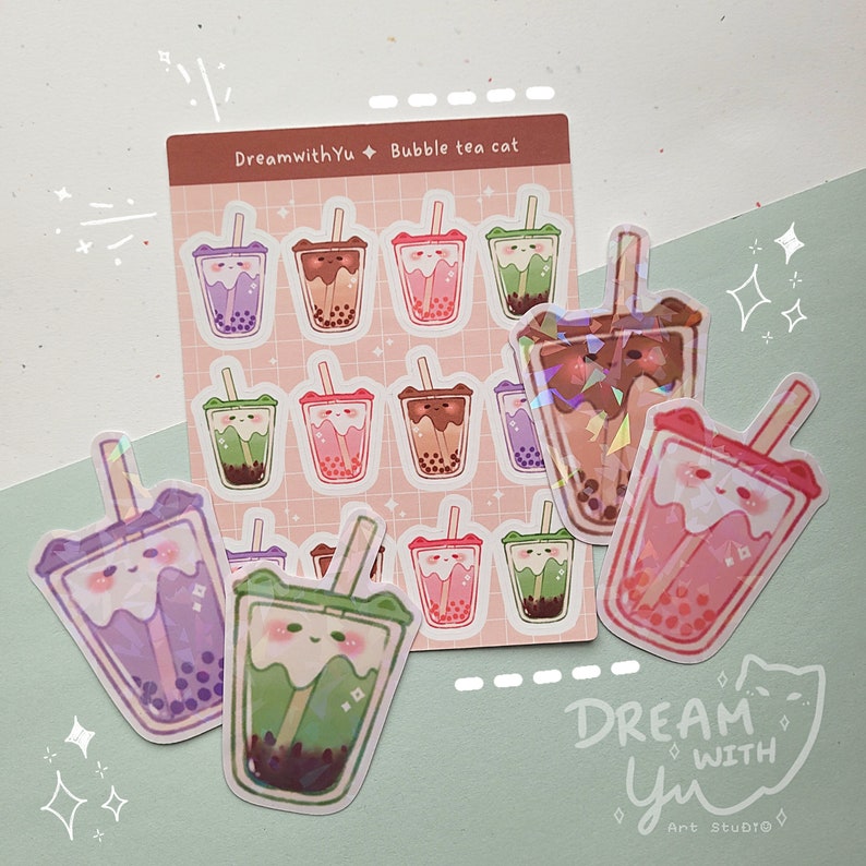 May include: A set of 12 holographic stickers featuring a cartoon cat drinking bubble tea. The stickers are on a pink background with the text "DreamwithYu Bubble tea cat".
