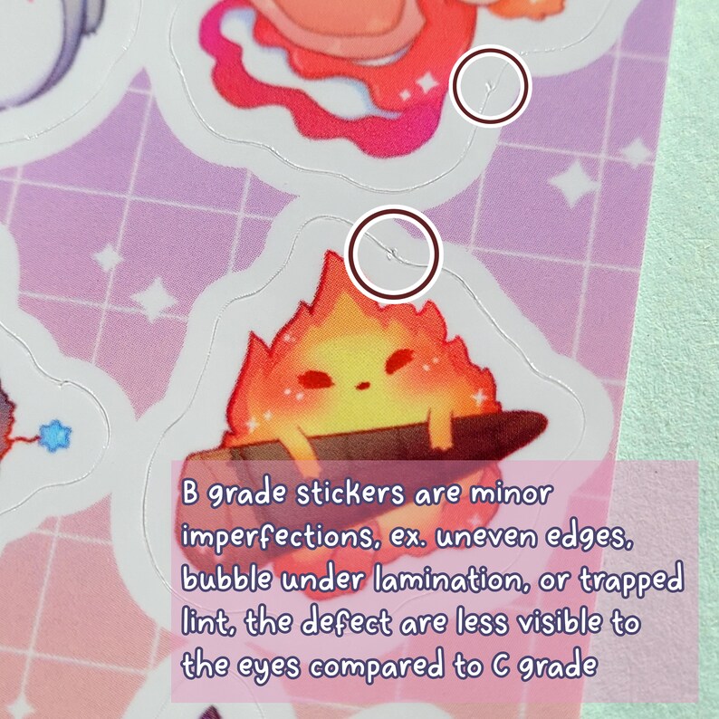 May include: Close-up of a sticker featuring a cartoon fire creature with a red and orange flame body. The sticker has a slight imperfection on the edge, which is a common characteristic of B grade stickers. The text below the sticker reads: "B grade stickers are minor imperfections, ex. uneven edges, bubble under lamination, or trapped lint, the defect are less visible to the eyes compared to C grade."