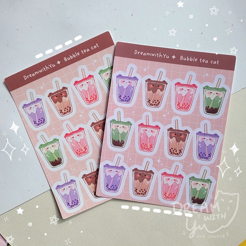 May include: Two sheets of stickers featuring a cartoon cat drinking bubble tea. The stickers are pink with white outlines and feature different coloured bubble tea cups. The text "DreamwithYu Bubble tea cat" is printed on each sheet.
