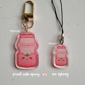 May include: Two pink strawberry yogurt bottle charms, one with a clear epoxy coating on the front and one without. The charm with epoxy is 45 mm tall and the charm without epoxy is 30 mm tall.