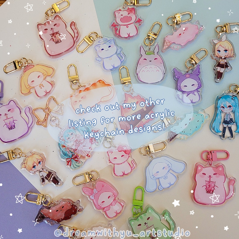 May include: A collection of colorful acrylic keychains featuring various characters, including anime characters, animals, and cartoon figures. The keychains are displayed on a light pink and white background. The text "check out my other listing for more acrylic keychain designs!" is written in black text on a white background.