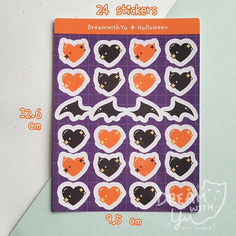 May include: A sheet of 24 Halloween themed stickers featuring orange and black hearts, bats, and stars. The sheet measures 9.5 inches by 12.6 inches. The text "DreamwithYu Halloween" is printed at the top of the sheet.