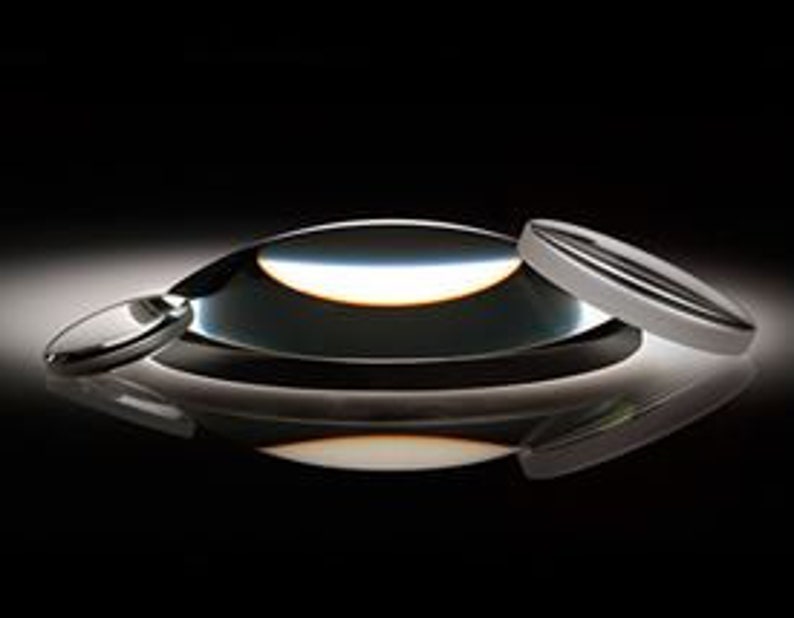May include: Three clear glass lenses of different sizes. The largest lens is a convex lens, the medium lens is a plano-convex lens, and the smallest lens is a plano-concave lens.