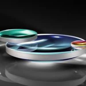 May include: Three round glass lenses, one large and two smaller, with a silver rim around the large lens. The lenses are clear with a slight blue tint and a reflective surface.