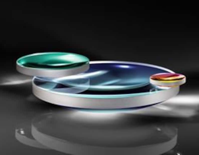 May include: Three round glass lenses, one large and two smaller, with a silver rim around the large lens. The lenses are clear with a slight blue tint and a reflective surface.