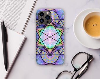 May include: A smartphone case with a geometric design in shades of purple, blue, green, and yellow. The case features a complex pattern of lines and shapes, with a central star-like design. The case is on a white surface with a cup of coffee, glasses, and a pen.