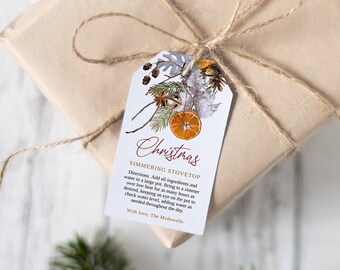 Puede incluir: Una bolsa de regalo de papel marrón atada con cuerda y una etiqueta de regalo. La etiqueta de regalo tiene un diseño floral con naranjas y el texto "Christmas Simmering Stovetop" y "Warm wishes, The Meadows".