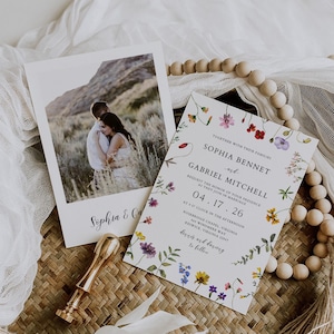 May include: Wedding invitation suite featuring a photo card and a floral-bordered invitation. The invitation includes the names Sophia Bennet and Gabriel Mitchell, with the date 04.17.26. A gold wax seal and decorative elements complete the arrangement.