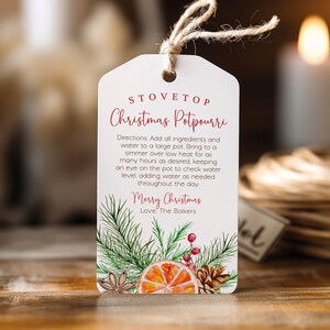 May include: A white gift tag with red text that reads "Stovetop Christmas Potpourri". The tag has instructions for making a Christmas potpourri and includes a festive illustration of pine branches, berries, and an orange slice.