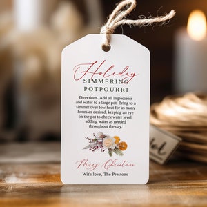 May include: White gift tag with red text that reads "Holiday Simmering Potpourri". Directions for making potpourri are listed below the title. The tag is decorated with a floral illustration and the text "Merry Christmas" in red. The text "With love, The Prestons" is at the bottom of the tag.