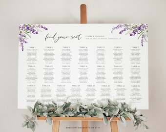 May include: A wedding seating chart with a lavender floral design. The chart is printed on white cardstock and features the text "find your seat" and the names Claire & Nicholas. The chart lists the names of guests assigned to each table number.