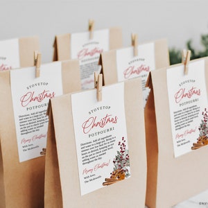 May include: Several brown paper bags with white tags clipped on top. The tags read "Stovetop Christmas Potpourri" in red script. The tags also include instructions and a decorative image of cinnamon sticks and berries. The bags are for a holiday theme.