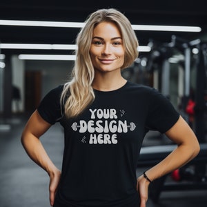 May include: A black t-shirt with the text "YOUR DESIGN HERE" and a dumbbell graphic printed on the front.