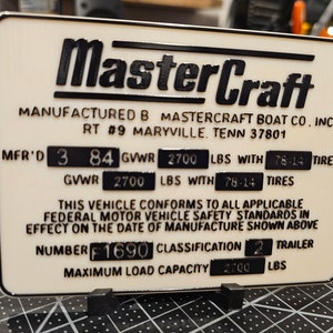 May include: A white MasterCraft boat company identification plate with black text. The plate states "Manufactured by MasterCraft Boat Co. Inc. RT #9 Maryville, Tenn 37801". The plate also includes the following information: MFR'D 3 84 GVWR 2700 LBS WITH 78-14 TIRES, GVWR 2700 LBS WITH 78-14 TIRES, THIS VEHICLE CONFORMS TO ALL APPLICABLE FEDERAL MOTOR VEHICLE SAFETY STANDARDS IN EFFECT ON THE DATE OF MANUFACTURE SHOWN ABOVE, NUMBER F 1690 CLASSIFICATION 2 TRAILER, MAXIMUM LOAD CAPACITY 2700 LBS.