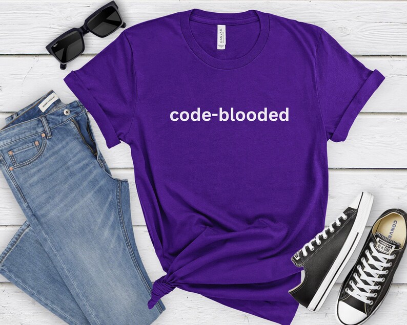 a purple t - shirt that says code - blooded next to a pair of