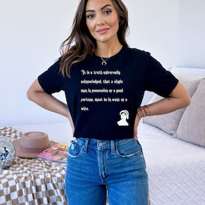 May include: A black t-shirt featuring a white quote from Jane Austen's Pride and Prejudice: "It is a truth universally acknowledged, that a single man in possession of a good fortune, must be in want of a wife."