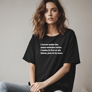 Könnte beinhalten: Schwarzes T-Shirt mit weißem Text, der lautet: "Ich mache denselben Fehler nie zweimal. Ich mache ihn fünf oder sechs Mal, nur um sicherzugehen."
