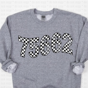 May include: A grey sweatshirt with a black and white chequered number "75662" printed on the front.