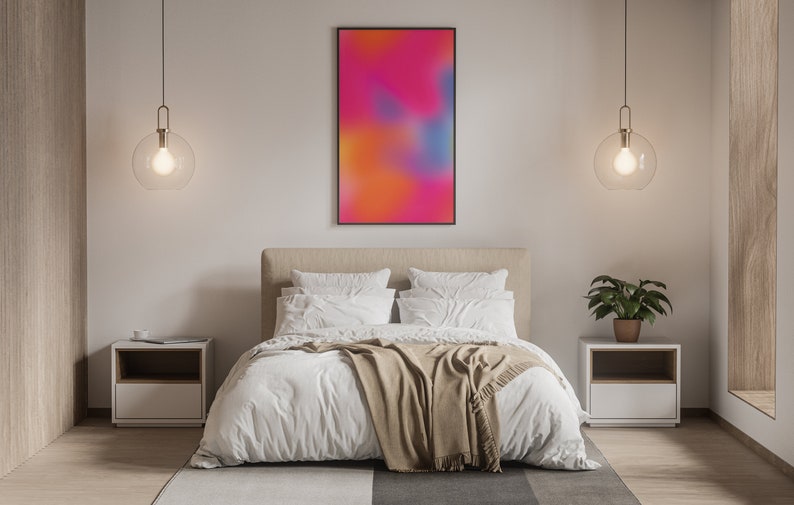 May include: A bedroom with a white bed, a tan blanket, and two white nightstands with lamps. A framed abstract painting with pink, orange, and blue colors hangs on the wall above the bed.