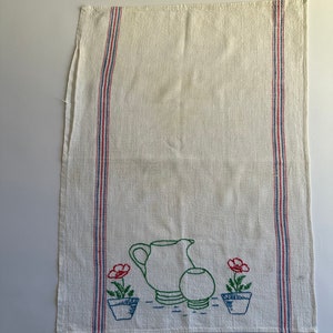 May include: White kitchen towel with red, blue, and green embroidered stripes and a design of a pitcher, a bowl, and two potted flowers with red blooms.