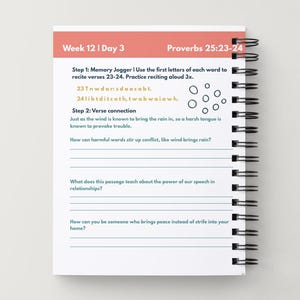 May include: A spiral-bound notebook with a white interior and a light peach header that reads "Week 12 | Day 3". The text includes "Proverbs 25:23-24" and prompts for verse recitation and reflection questions.
