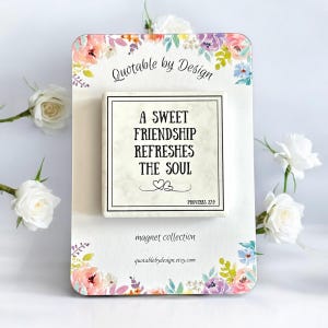 May include: A white square magnet with a floral design border. The magnet features a quote: "A sweet friendship refreshes the soul."  The quote is attributed to Proverbs 27:9. The magnet is part of a collection called "Quotable by Design".