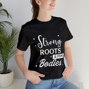 Camiseta fitness mujer, raíces fuertes y cuerpos fuertes.