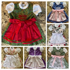 Pode incluir: Uma colagem de seis vestidos dirndl coloridos. Cada vestido apresenta um corpete, uma saia e um avental branco. Os vestidos variam em cor e padr&atilde;o, incluindo desenhos florais, de frutos silvestres e lisos. Os aventais t&ecirc;m detalhes de ilh&oacute;s.