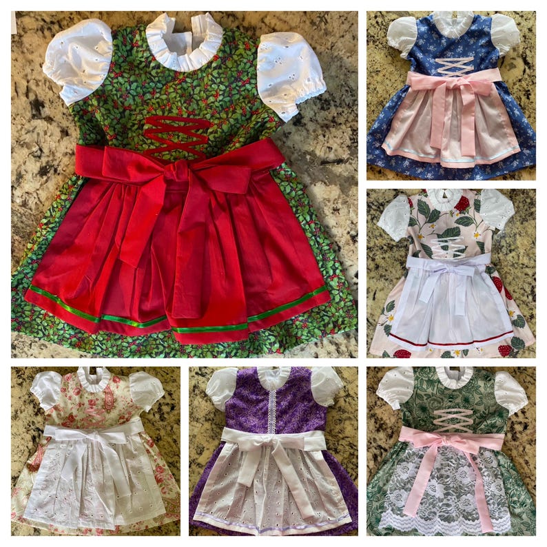 Pode incluir: Uma colagem de seis vestidos dirndl coloridos. Cada vestido apresenta um corpete, uma saia e um avental branco. Os vestidos variam em cor e padr&atilde;o, incluindo desenhos florais, de frutos silvestres e lisos. Os aventais t&ecirc;m detalhes de ilh&oacute;s.