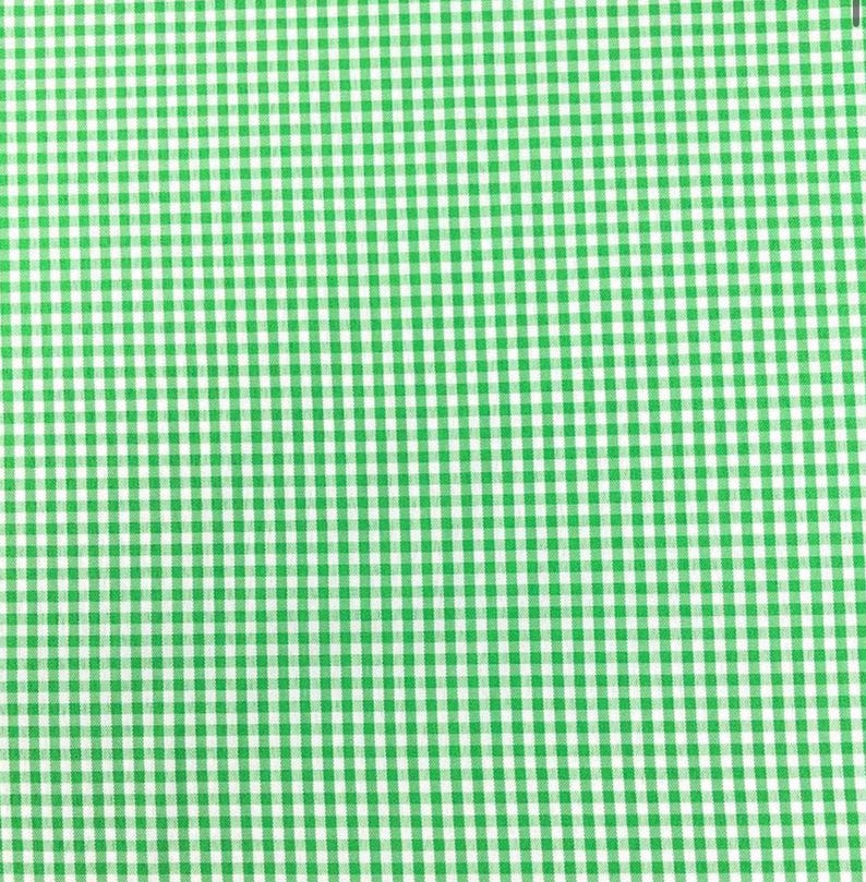 Puede incluir: Un tejido textil que presenta un patr&oacute;n de cuadros vichy repetitivo compuesto por peque&ntilde;os cuadrados uniformes en verde brillante y blanco. El dise&ntilde;o consiste en una cuadr&iacute;cula consistente de bloques alternos de color y blanco.