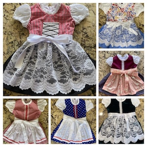 Pode incluir: Uma cole&ccedil;&atilde;o de vestidos dirndl coloridos. Os vestidos apresentam v&aacute;rios designs, incluindo xadrez vermelho, estampas florais e cores s&oacute;lidas. Cada vestido tem uma saia de renda branca, um avental branco e um la&ccedil;o na cintura. Os vestidos t&ecirc;m mangas curtas e bufantes.