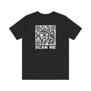 Op de afbeelding: Een zwart T-shirt met een witte QR-code en de tekst "SCAN ME" gedrukt op de voorkant.