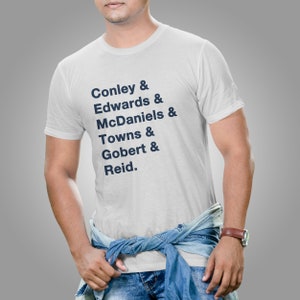 May include: White t-shirt with a navy blue print listing the names Conley, Edwards, McDaniels, Towns, Gobert, and Reid, each followed by an ampersand.