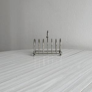 Shiny silver metal toast rack, vintage breakfast accessory, elegant table decor, refined home gift, stylish brunch