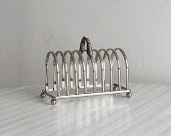 Porta tostadas de metal brillante, accesorio de mesa vintage, objeto decorativo de diseño para brunch, desayuno o cocina retro.