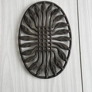 Vintage gietijzeren onderzetter, zon- of gestileerd bloemenontwerp, rustieke keukeninrichting, zwart gietijzer, origineel retro-accessoire