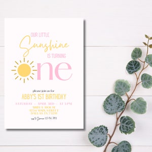 K&ouml;nnte beinhalten: Eine gelbe Sonne mit Strahlen und eine rosafarbene Eins auf wei&szlig;em Hintergrund. Der Text "Our Little Sunshine is Turning" befindet sich &uuml;ber der Sonne und der Eins. Der Text "Please join us for Abby's 1st Birthday" befindet sich unter der Sonne und der Eins. Der Text "Saturday - April 3rd - At 3 PM" befindet sich unter dem Text "Abby's 1st Birthday". Der Text "Abby's House 1234 Main Street Dallas TX 75214" befindet sich unter dem Text "Saturday - April 3rd - At 3 PM". Der Text "RSVP to Shannon 123.456.7690" befindet sich unter dem Text "Abby's House 1234 Main Street Dallas TX 75214".