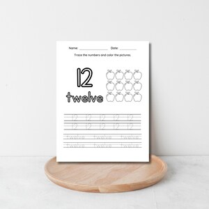 以下が含まれることがあります： 数字の12と「twelve」という単語をなぞるための白黒の印刷可能なワークシート。ワークシートには、12個のリンゴを色塗りするためのセクションも含まれています。