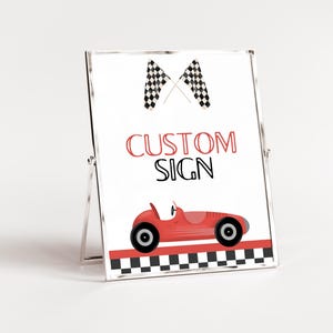 May include: A white sign with a red race car and checkered flag design. The sign says "CUSTOM SIGN" in black letters.