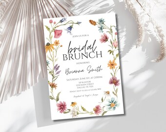 Può includere: Un invito a un brunch di nozze floreale con una ghirlanda di fiori ad acquerello in tonalità di rosa, blu, giallo e verde. Il testo recita "Join us for a bridal brunch honoring Brianna Smith, Saturday, June 1st, at 2:00pm, Sip & Savor, 1234 Main Street, Dallas, TX 75211, Kindly RSVP to Jess at 1234567890, Registered at Target & Amazon."