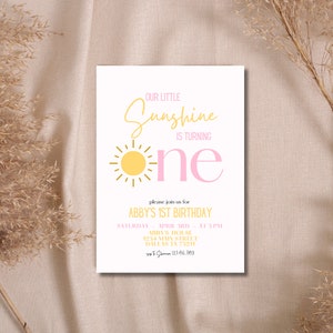 K&ouml;nnte beinhalten: Eine rosafarbene und gelbe Geburtstagseinladung mit einer Sonnengrafik und dem Text "Our Little Sunshine is Turning One". Die Einladung enth&auml;lt die Details f&uuml;r Abbys 1. Geburtstagsparty, einschlie&szlig;lich Datum, Uhrzeit, Ort und Kontaktinformationen.