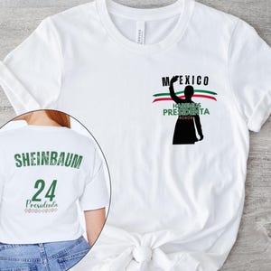 Puede incluir: Camiseta blanca con un diseño gráfico que presenta la palabra "MEXICO" sobre una silueta de una persona levantando la mano, con las palabras "HABEMUS PRESIDENTA" debajo. La parte posterior de la camiseta muestra el nombre "SHEINBAUM", el número "24" y la palabra "Presidenta".