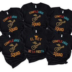 Puede incluir: Camisetas negras con texto y gráficos coloridos. Las camisetas presentan las palabras "Cumpleaños Squad" y "El Rey De La Fiesta" con un diseño de guitarra y sombrero de vaquero. Perfectas para una celebración de cumpleaños.