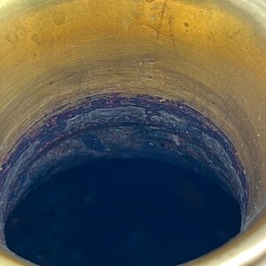 Puede incluir: Primer plano del interior de un jarr&oacute;n decorativo. El borde superior es de color dorado brillante y el interior es azul oscuro. El jarr&oacute;n tiene un dise&ntilde;o detallado en el exterior, con una combinaci&oacute;n de colores azul y dorado.