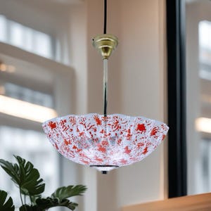 May include: A white and red patterned glass pendant light fixture with a gold metal canopy.
